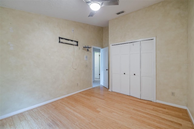 unfurnished bedroom with ceiling fan, a closet, and light hardwood / wood-style floors