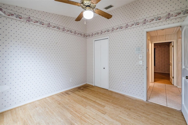 unfurnished bedroom with ceiling fan, a closet, and light hardwood / wood-style floors