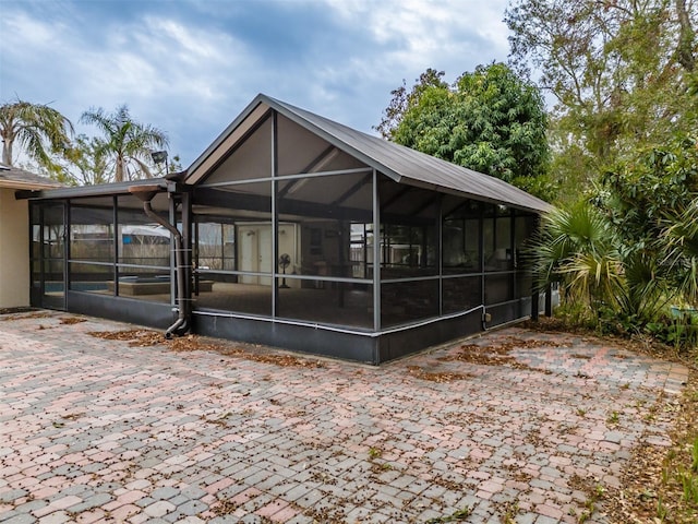 back of house with a patio area and glass enclosure