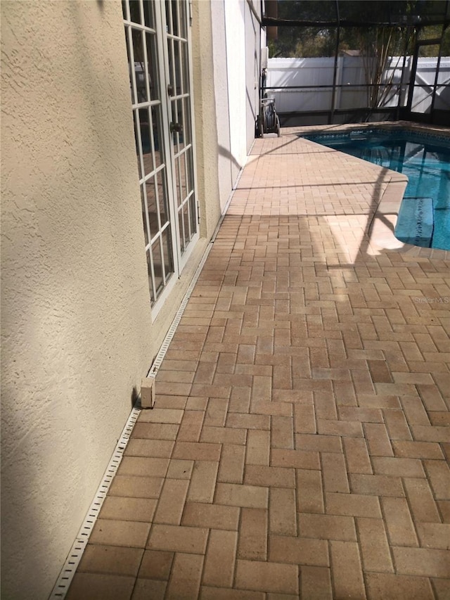 view of swimming pool featuring french doors, a patio area, a lanai, and a fenced in pool