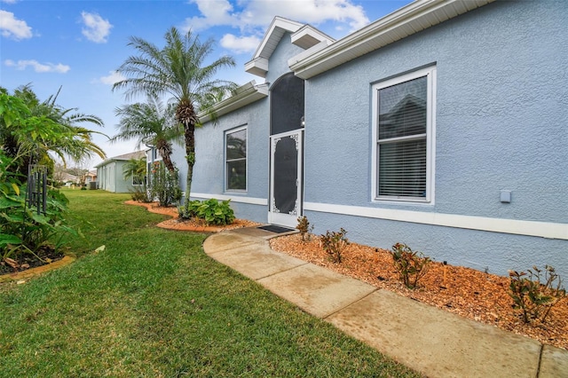 doorway to property featuring a yard