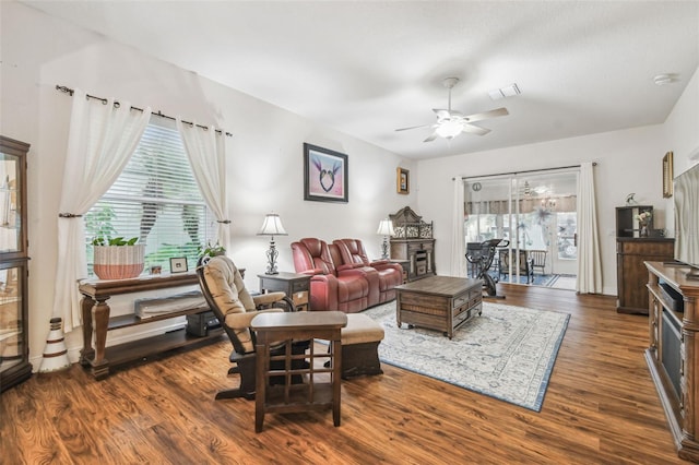 living room with ceiling fan, dark hardwood / wood-style floors, and a fireplace