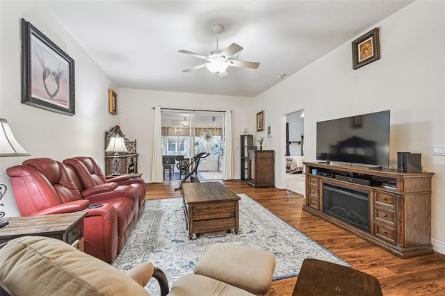 living room with ceiling fan and dark hardwood / wood-style flooring