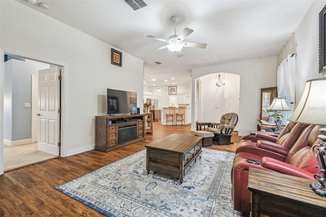 living room featuring ceiling fan, hardwood / wood-style floors, and a fireplace