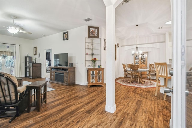 living room featuring dark wood-type flooring and ceiling fan with notable chandelier