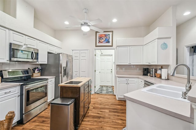 kitchen featuring decorative backsplash, white cabinets, appliances with stainless steel finishes, and sink