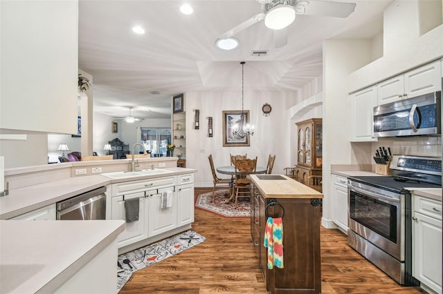 kitchen featuring sink, white cabinets, pendant lighting, stainless steel appliances, and dark hardwood / wood-style floors