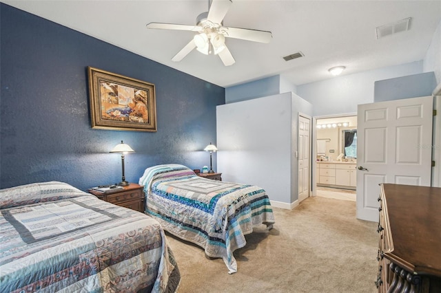 bedroom featuring ceiling fan, ensuite bathroom, and light carpet