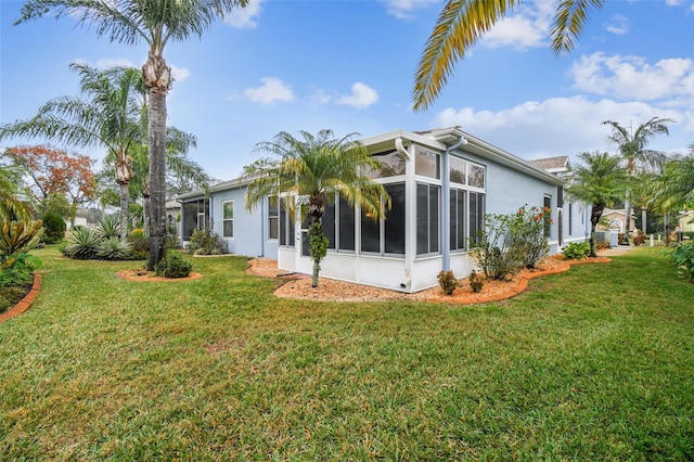 back of property featuring a yard and a sunroom