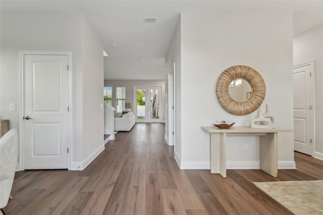 corridor with hardwood / wood-style flooring and french doors