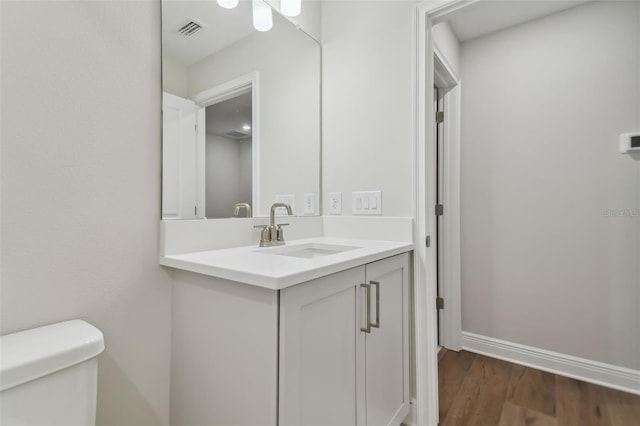 bathroom featuring hardwood / wood-style flooring, toilet, and vanity