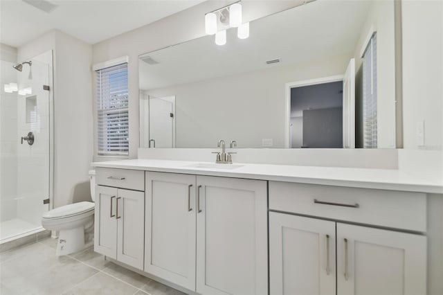 bathroom with an enclosed shower, vanity, and tile patterned flooring