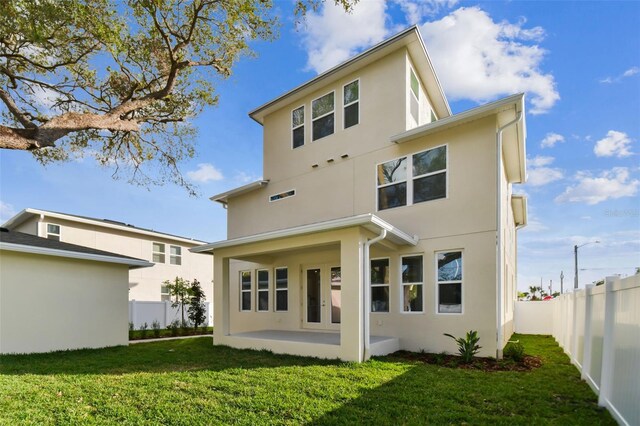 rear view of property featuring a patio and a yard