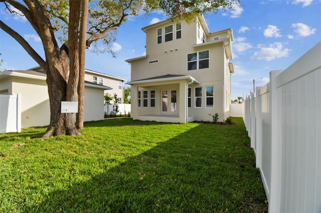 rear view of property with a lawn