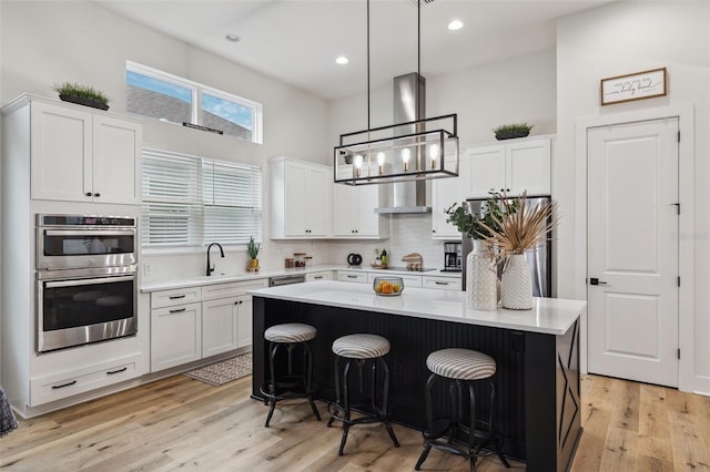 kitchen with white cabinetry, stainless steel appliances, a center island, and a breakfast bar area