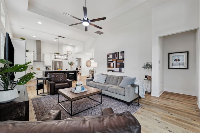 living room with ceiling fan and light hardwood / wood-style flooring