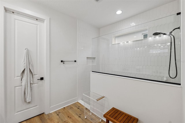 bathroom with hardwood / wood-style flooring and a shower