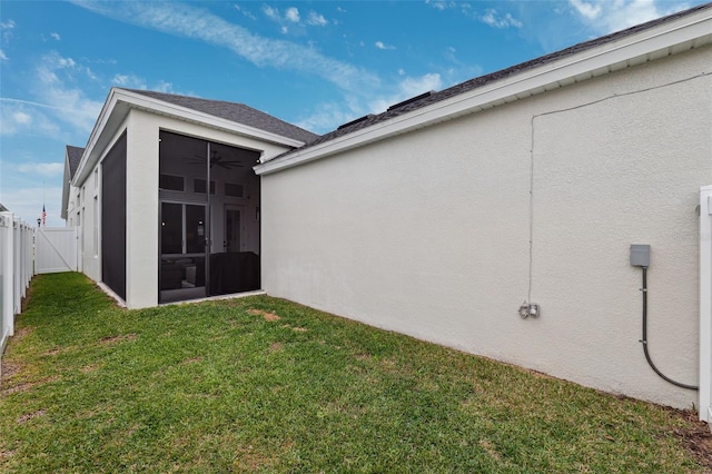 rear view of property featuring a lawn and ceiling fan