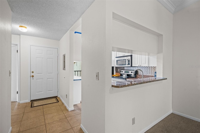 foyer featuring a textured ceiling and baseboards