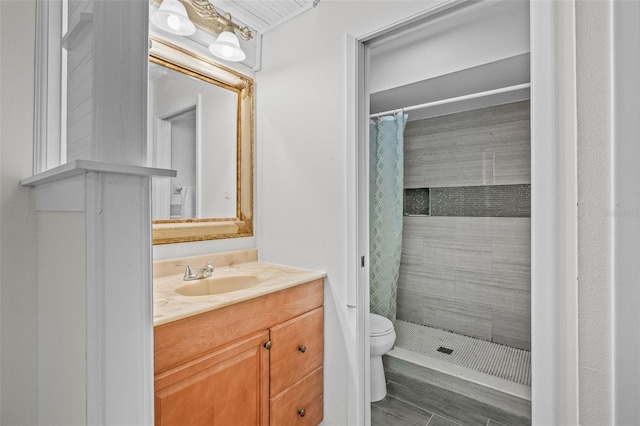 bathroom with toilet, a shower stall, and vanity