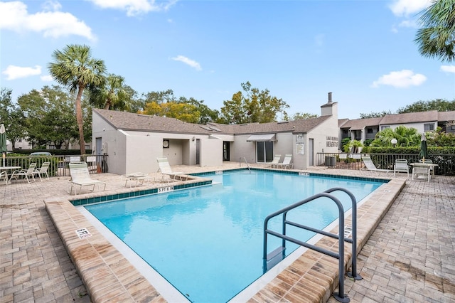 community pool featuring a patio area and fence