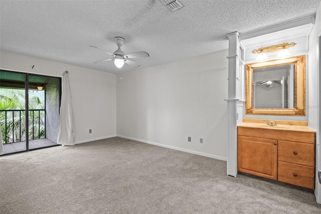 spare room with a ceiling fan, light carpet, visible vents, and baseboards