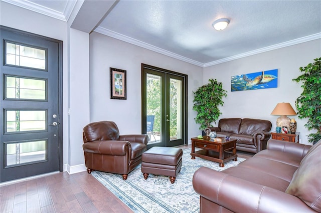 living room with a textured ceiling, hardwood / wood-style floors, crown molding, and french doors