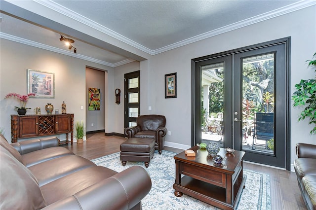 living room featuring hardwood / wood-style flooring, ornamental molding, a textured ceiling, and french doors