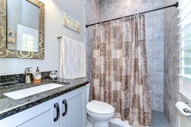 bathroom featuring toilet, walk in shower, and vanity