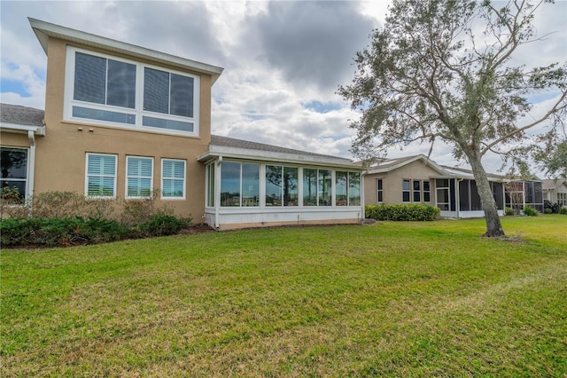 back of house featuring a lawn and a sunroom