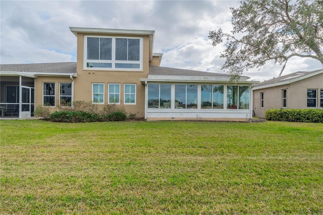 back of property with a sunroom and a yard