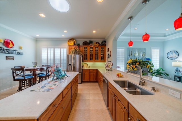 kitchen with sink, crown molding, hanging light fixtures, appliances with stainless steel finishes, and plenty of natural light