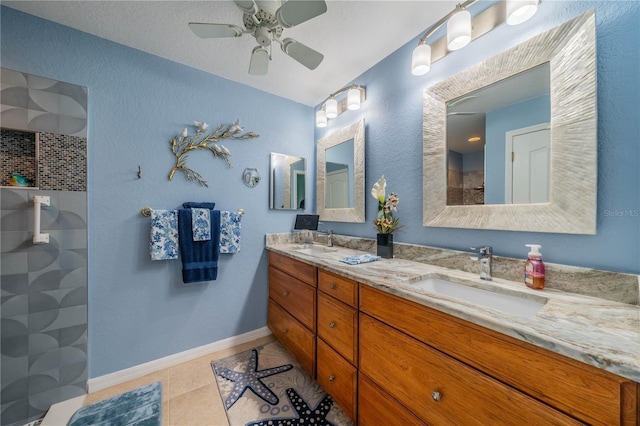 bathroom with tile patterned flooring, vanity, tiled shower, and ceiling fan