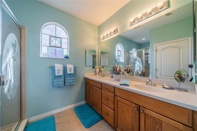 bathroom with tile patterned flooring, vanity, a wealth of natural light, and a shower with shower door