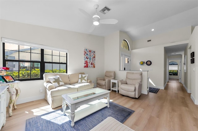 living room featuring ceiling fan, vaulted ceiling, and light hardwood / wood-style flooring