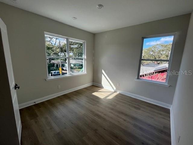 unfurnished bedroom featuring baseboards and dark wood-type flooring