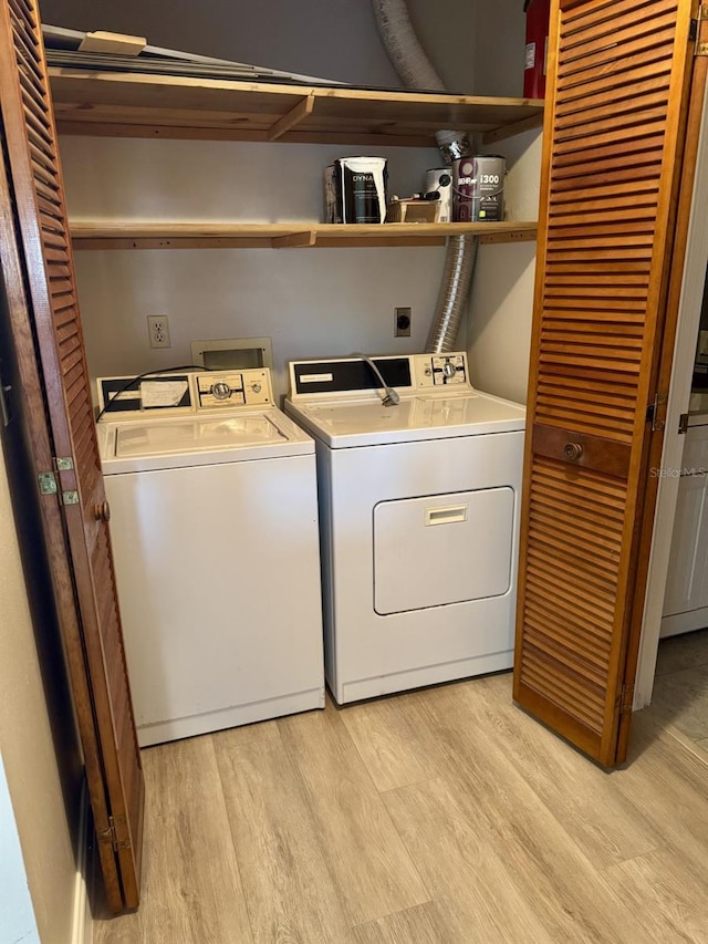 washroom featuring washing machine and dryer and light hardwood / wood-style floors