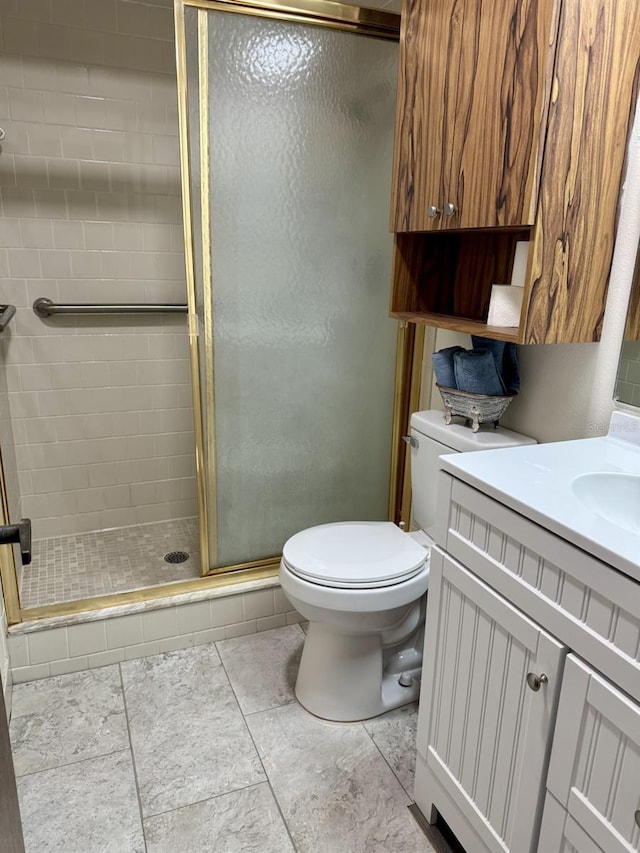 bathroom featuring toilet, an enclosed shower, and vanity