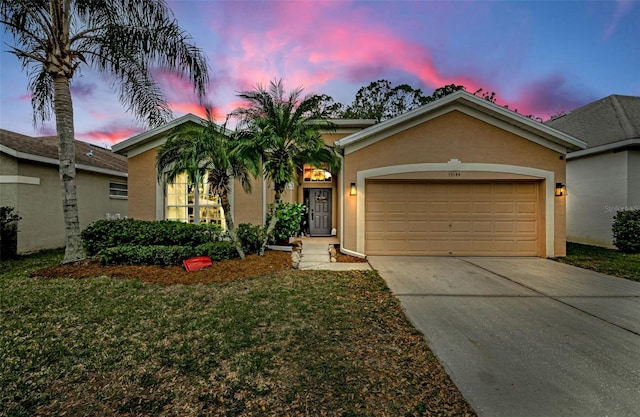 view of front of home featuring a garage and a yard