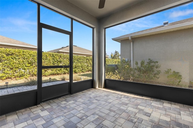 unfurnished sunroom with ceiling fan