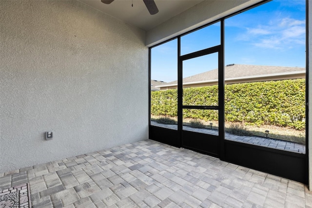 unfurnished sunroom featuring ceiling fan