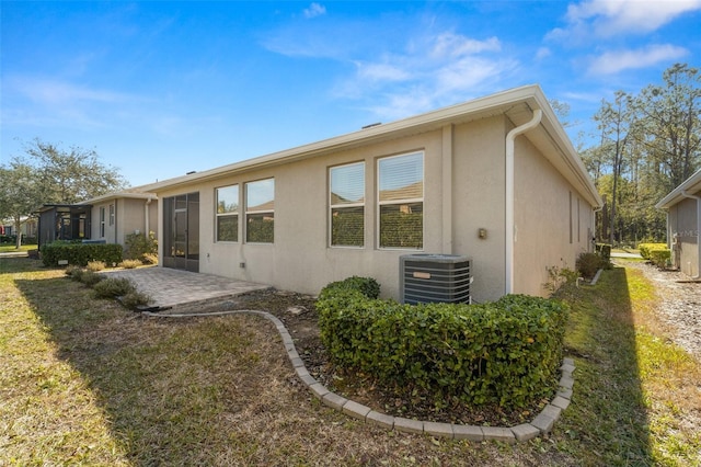 view of home's exterior featuring central AC unit, a patio area, and a lawn