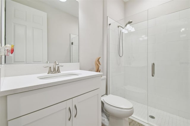 bathroom with toilet, vanity, and an enclosed shower