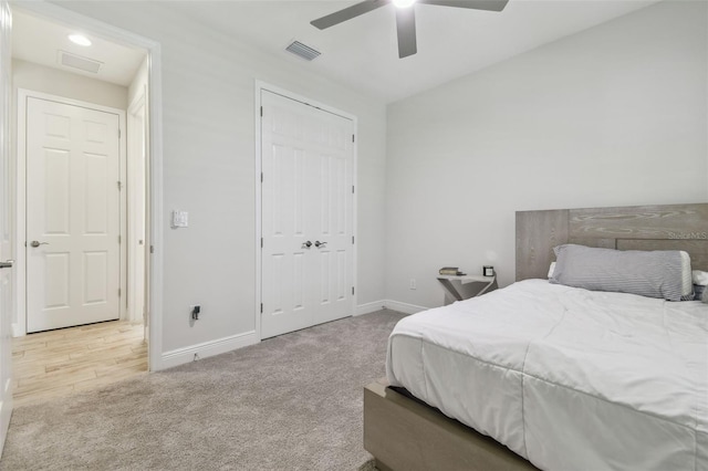 bedroom with light carpet, a closet, and ceiling fan