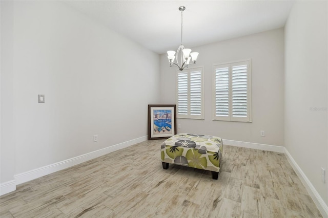 living area with light hardwood / wood-style flooring and an inviting chandelier