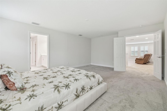 carpeted bedroom featuring ensuite bathroom