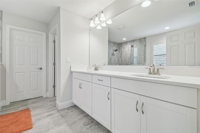 bathroom featuring a tile shower and vanity