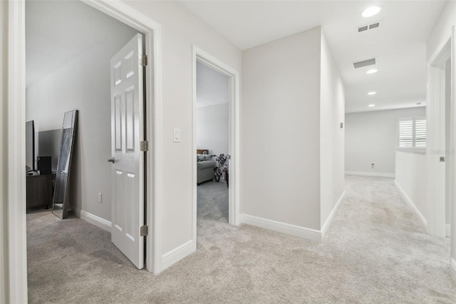 hallway featuring light colored carpet