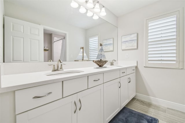 bathroom with a shower with curtain, a healthy amount of sunlight, tile patterned flooring, and vanity