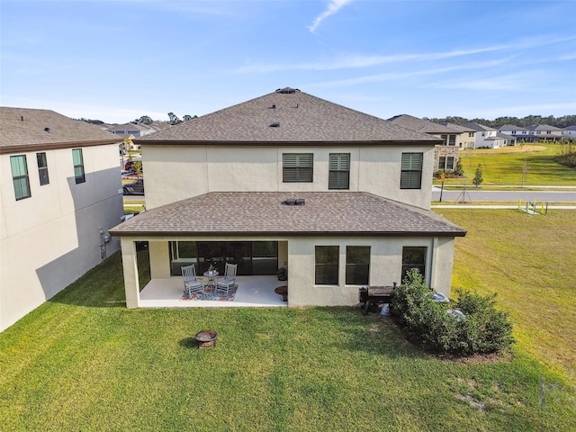 rear view of property with a yard and a patio